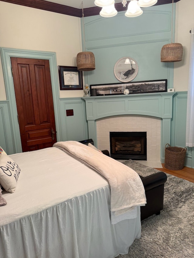 529 Fountain St NE, Grand Rapids, MI 49503 - bedroom with a decorative wall, a wainscoted wall, a fireplace, and wood finished floors