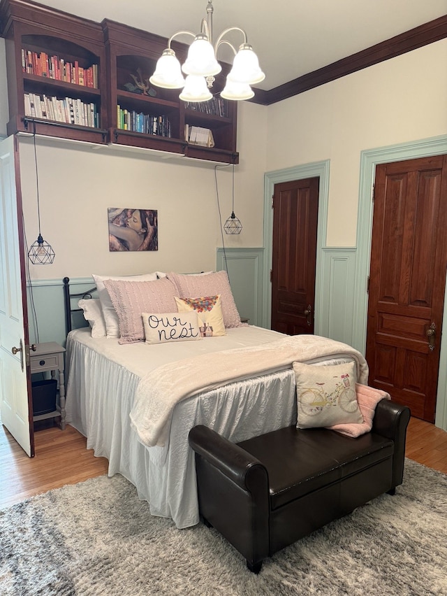 529 Fountain St NE, Grand Rapids, MI 49503 - bedroom with wood finished floors, a chandelier, ornamental molding, and wainscoting