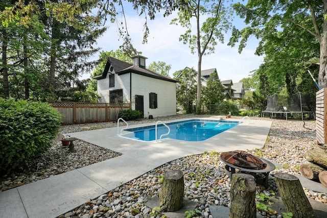 529 Fountain St NE, Grand Rapids, MI 49503 - view of swimming pool featuring a fire pit, a trampoline, a patio area, and a fenced backyard