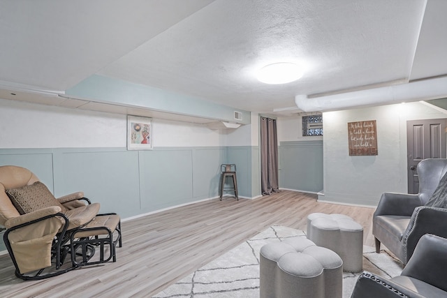 529 Fountain St NE, Grand Rapids, MI 49503 - sitting room featuring wood finished floors, a textured ceiling, and a wainscoted wall