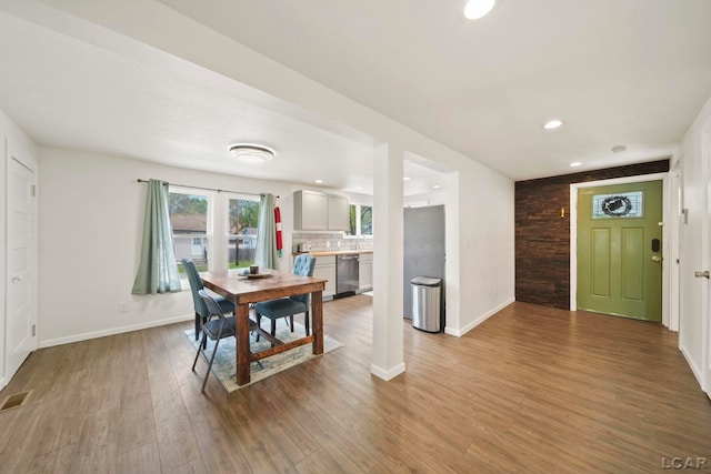 dining space featuring wood finished floors, baseboards, and recessed lighting