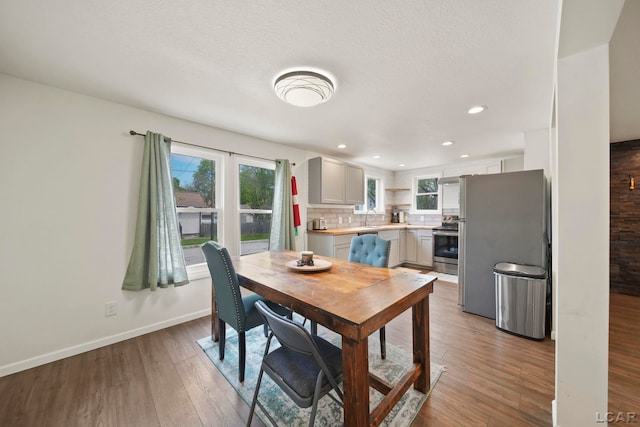 dining room with light wood-type flooring, baseboards, and recessed lighting