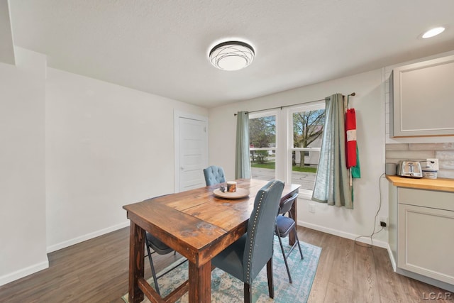 dining space with wood finished floors and baseboards