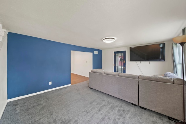carpeted living area featuring baseboards and healthy amount of natural light