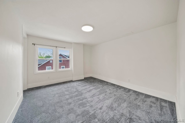carpeted spare room with baseboards