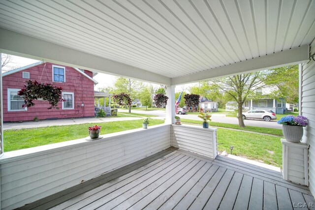 wooden deck with covered porch and a yard