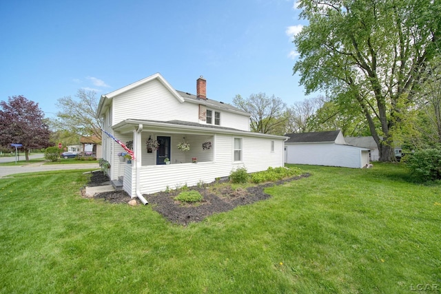 rear view of house with a chimney and a lawn