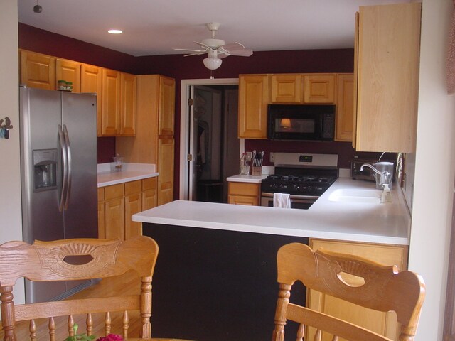 10832 Eagle Cove Dr, South Lyon, MI 48178 - kitchen featuring stainless steel appliances, a sink, light brown cabinetry, a peninsula, and light countertops