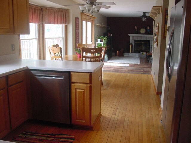 10832 Eagle Cove Dr, South Lyon, MI 48178 - kitchen featuring appliances with stainless steel finishes, a ceiling fan, open floor plan, light wood-type flooring, and light countertops