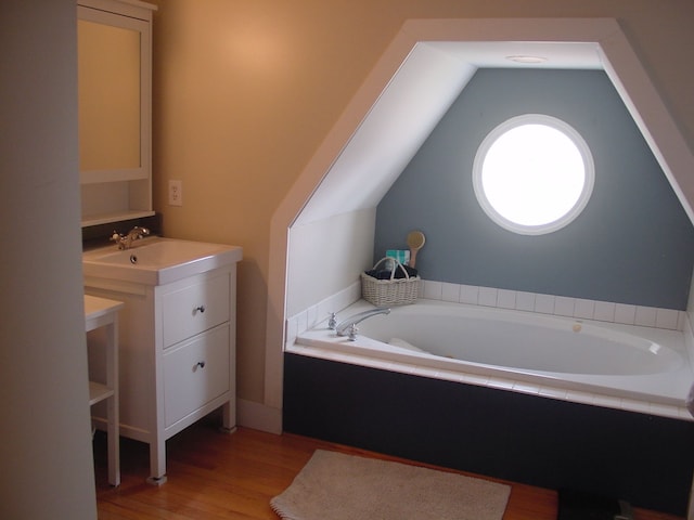 10832 Eagle Cove Dr, South Lyon, MI 48178 - bathroom with wood finished floors, a bath, vanity, and vaulted ceiling
