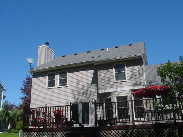 10832 Eagle Cove Dr, South Lyon, MI 48178 - rear view of property featuring a wooden deck, a chimney, and a shingled roof