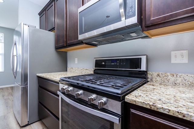 951 Barclay Cir Unit 48, Rochester Hills, MI 48307 - kitchen with stainless steel appliances, dark brown cabinets, light wood-style flooring, and light stone counters