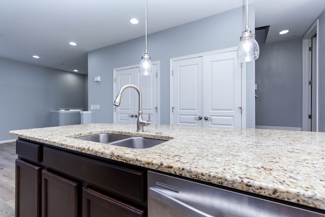 951 Barclay Cir Unit 48, Rochester Hills, MI 48307 - kitchen with a sink, stainless steel dishwasher, light wood-style floors, light stone countertops, and hanging light fixtures