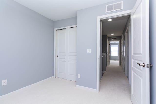 951 Barclay Cir Unit 48, Rochester Hills, MI 48307 - unfurnished bedroom featuring light carpet, a closet, baseboards, and recessed lighting