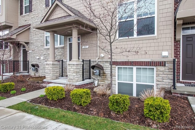 951 Barclay Cir Unit 48, Rochester Hills, MI 48307 - view of exterior entry with stone siding, a porch, and a shingled roof