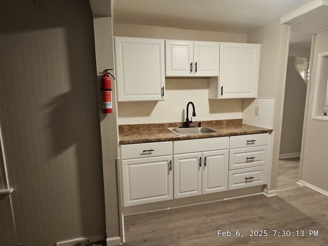 1778 Reo Ave, Lincoln Park, MI 48146 - kitchen featuring a sink, dark countertops, and white cabinets