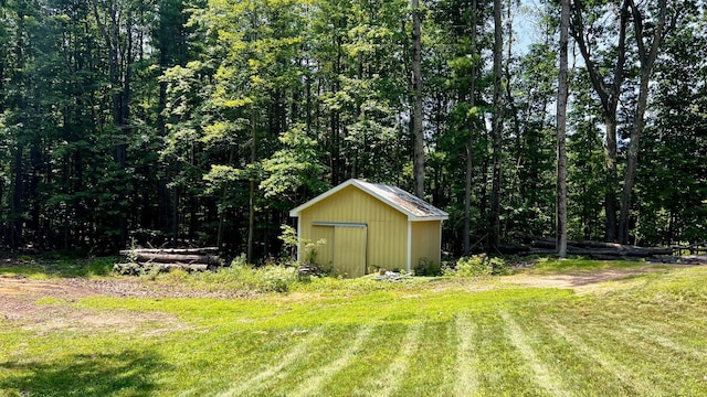 1821 W Hansen Rd, Scottville, MI 49454 - view of green lawn featuring an outbuilding, a storage unit, and a view of trees