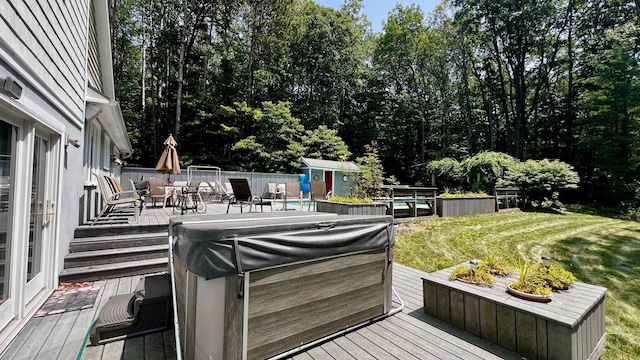 1821 W Hansen Rd, Scottville, MI 49454 - wooden deck with a hot tub, a storage shed, outdoor dining space, and an outbuilding