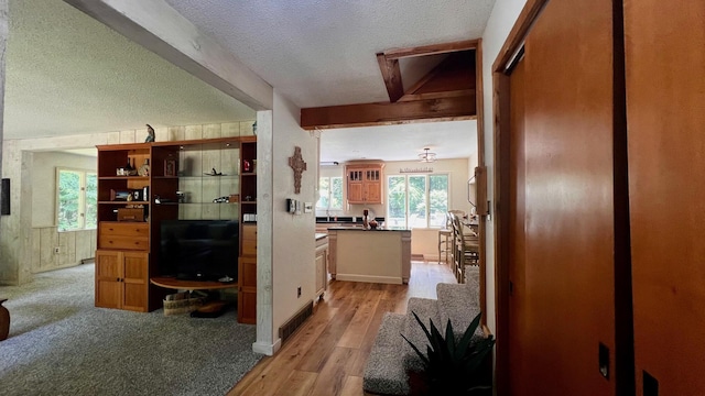 1821 W Hansen Rd, Scottville, MI 49454 - hall featuring a textured ceiling, light wood-type flooring, and beamed ceiling