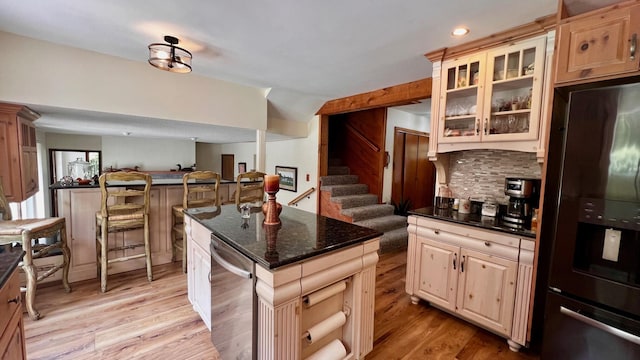 1821 W Hansen Rd, Scottville, MI 49454 - kitchen featuring black fridge with ice dispenser, open floor plan, light wood-style floors, glass insert cabinets, and recessed lighting