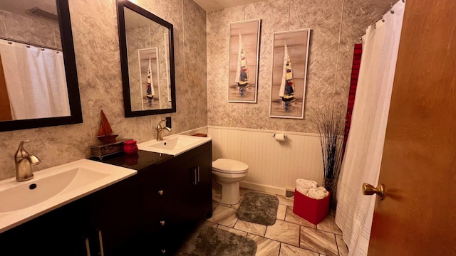 1821 W Hansen Rd, Scottville, MI 49454 - full bath with toilet, double vanity, a wainscoted wall, and a shower with curtain