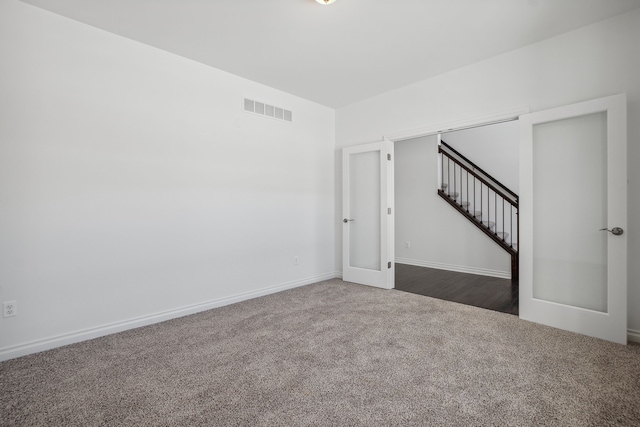 20859 Hasenclever Dr, South Lyon, MI 48178 - spare room with dark carpet, stairs, baseboards, and french doors