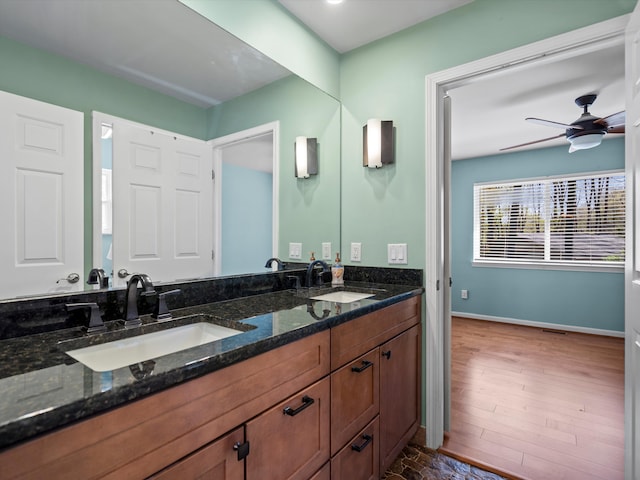 7111 Tucker Rd, Holly, MI 48442 - bathroom with ceiling fan, baseboards, double vanity, and wood finished floors