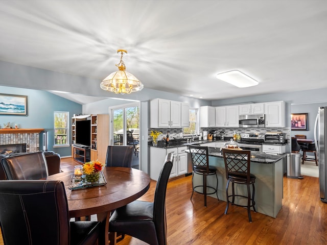 7111 Tucker Rd, Holly, MI 48442 - kitchen featuring stainless steel appliances, a chandelier, a center island, tasteful backsplash, and white cabinetry