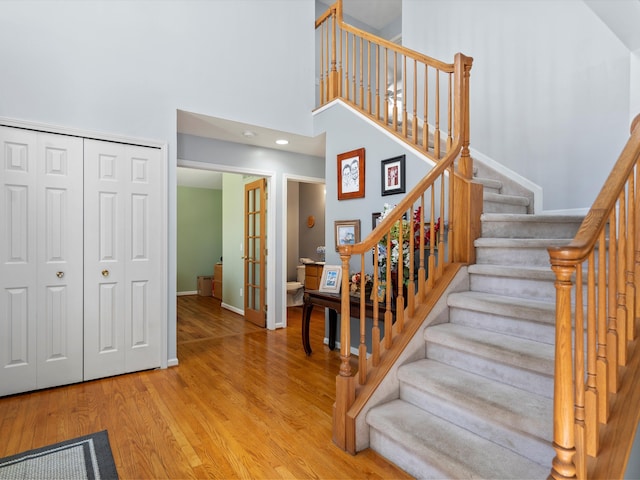 7111 Tucker Rd, Holly, MI 48442 - stairway featuring wood finished floors, french doors, baseboards, and a high ceiling