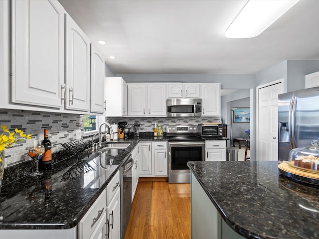 7111 Tucker Rd, Holly, MI 48442 - kitchen featuring appliances with stainless steel finishes, a sink, white cabinets, decorative backsplash, and recessed lighting