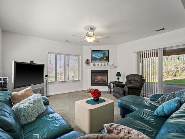 7111 Tucker Rd, Holly, MI 48442 - living area with carpet flooring, a ceiling fan, a glass covered fireplace, and baseboards