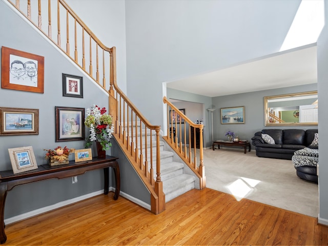 7111 Tucker Rd, Holly, MI 48442 - stairway featuring wood finished floors, a high ceiling, and baseboards