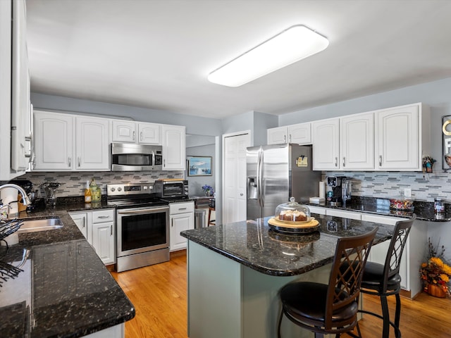 7111 Tucker Rd, Holly, MI 48442 - kitchen featuring appliances with stainless steel finishes, a sink, backsplash, and a breakfast bar area