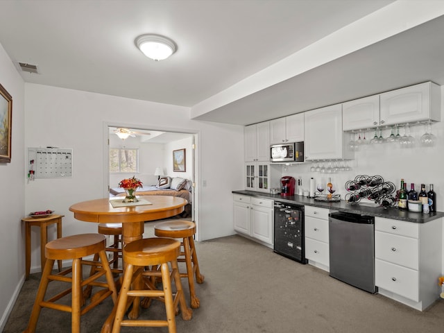 7111 Tucker Rd, Holly, MI 48442 - kitchen with wine cooler, refrigerator, stainless steel microwave, dark countertops, and white cabinets