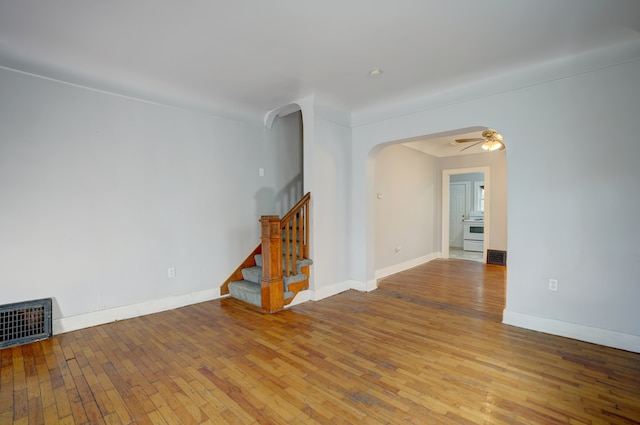 715 N St, Mount Morris, MI 48458 - unfurnished room featuring arched walkways, wood-type flooring, stairway, and a ceiling fan