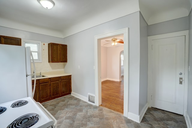715 N St, Mount Morris, MI 48458 - kitchen featuring white appliances, light countertops, arched walkways, and baseboards