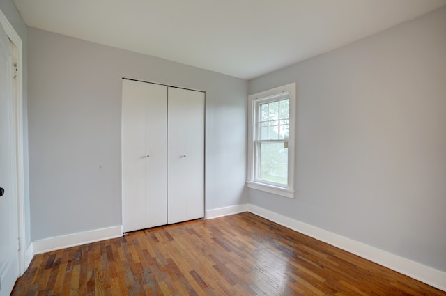 715 N St, Mount Morris, MI 48458 - unfurnished bedroom with wood-type flooring, baseboards, and a closet