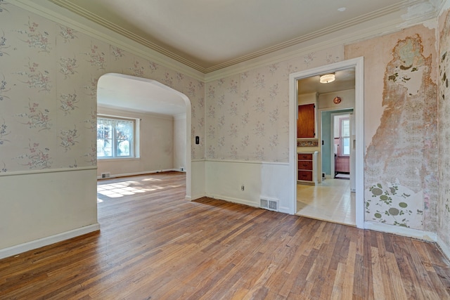 419 S State Rd, Davison, MI 48423 - spare room featuring arched walkways, wallpapered walls, wood finished floors, ornamental molding, and a wainscoted wall