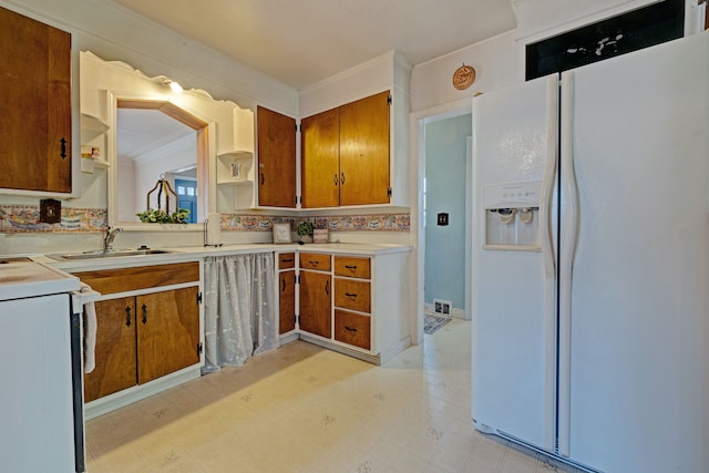 419 S State Rd, Davison, MI 48423 - kitchen with white refrigerator with ice dispenser, range with electric cooktop, brown cabinetry, and a sink