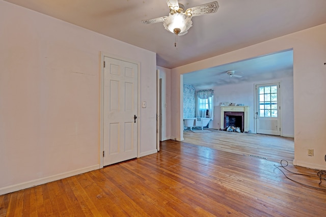 419 S State Rd, Davison, MI 48423 - unfurnished living room featuring a ceiling fan, hardwood / wood-style flooring, baseboards, and a fireplace