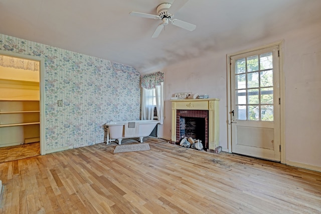 419 S State Rd, Davison, MI 48423 - unfurnished living room with wallpapered walls, wood finished floors, a brick fireplace, and a ceiling fan