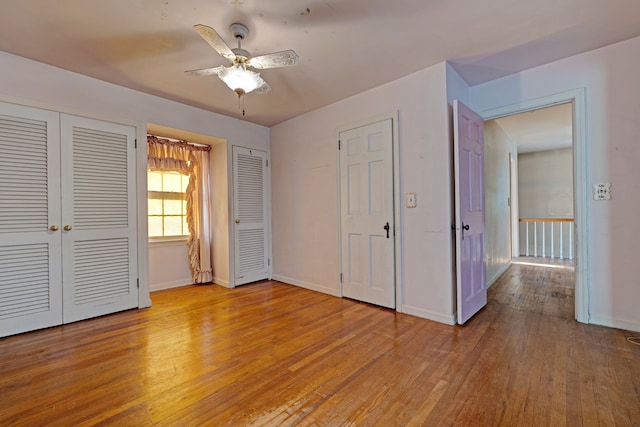 419 S State Rd, Davison, MI 48423 - unfurnished bedroom with two closets, light wood finished floors, baseboards, and a ceiling fan
