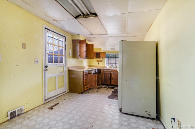 54 W Rockwood St, Ecorse, MI 48229 - kitchen with freestanding refrigerator, light floors, light countertops, brown cabinets, and a sink