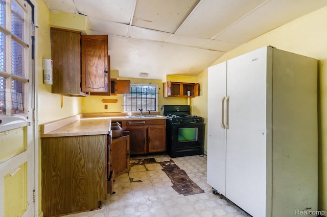 54 W Rockwood St, Ecorse, MI 48229 - kitchen featuring black gas stove, freestanding refrigerator, light flooring, a sink, and light countertops