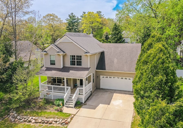 traditional-style home with covered porch, concrete driveway, a garage, and roof with shingles