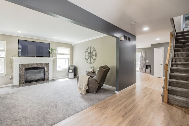 living area with ornamental molding, stairway, baseboards, light wood finished floors, and recessed lighting