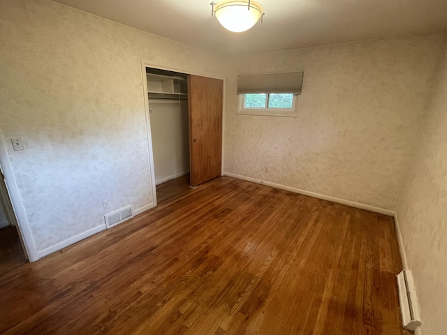 950 Raymond St, Ann Arbor, MI 48103 - unfurnished bedroom featuring wood finished floors, a closet, baseboards, and a baseboard radiator