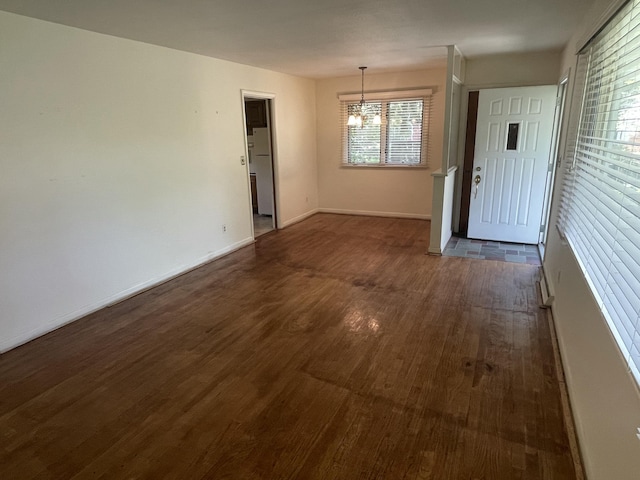 950 Raymond St, Ann Arbor, MI 48103 - unfurnished dining area with a chandelier, dark wood-type flooring, and baseboards