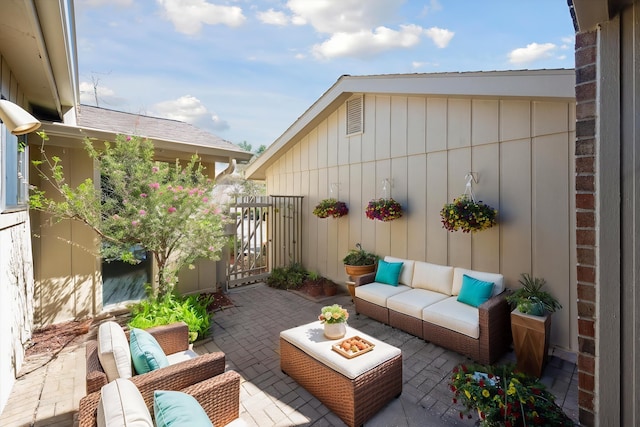 view of patio with an outdoor living space and a gate