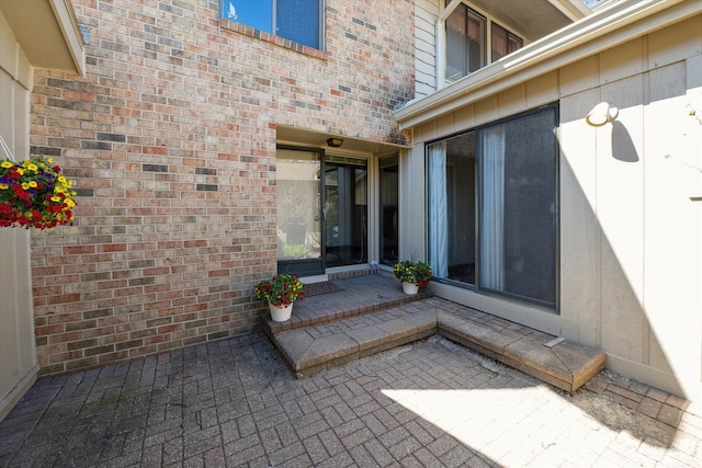 view of exterior entry with brick siding